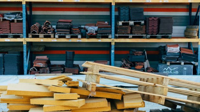 Assorted recycled building materials neatly arranged on warehouse shelving.